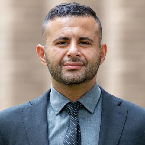 Pictured: Khaled Beydoun. Portrait of a person in a blue suit and tie.